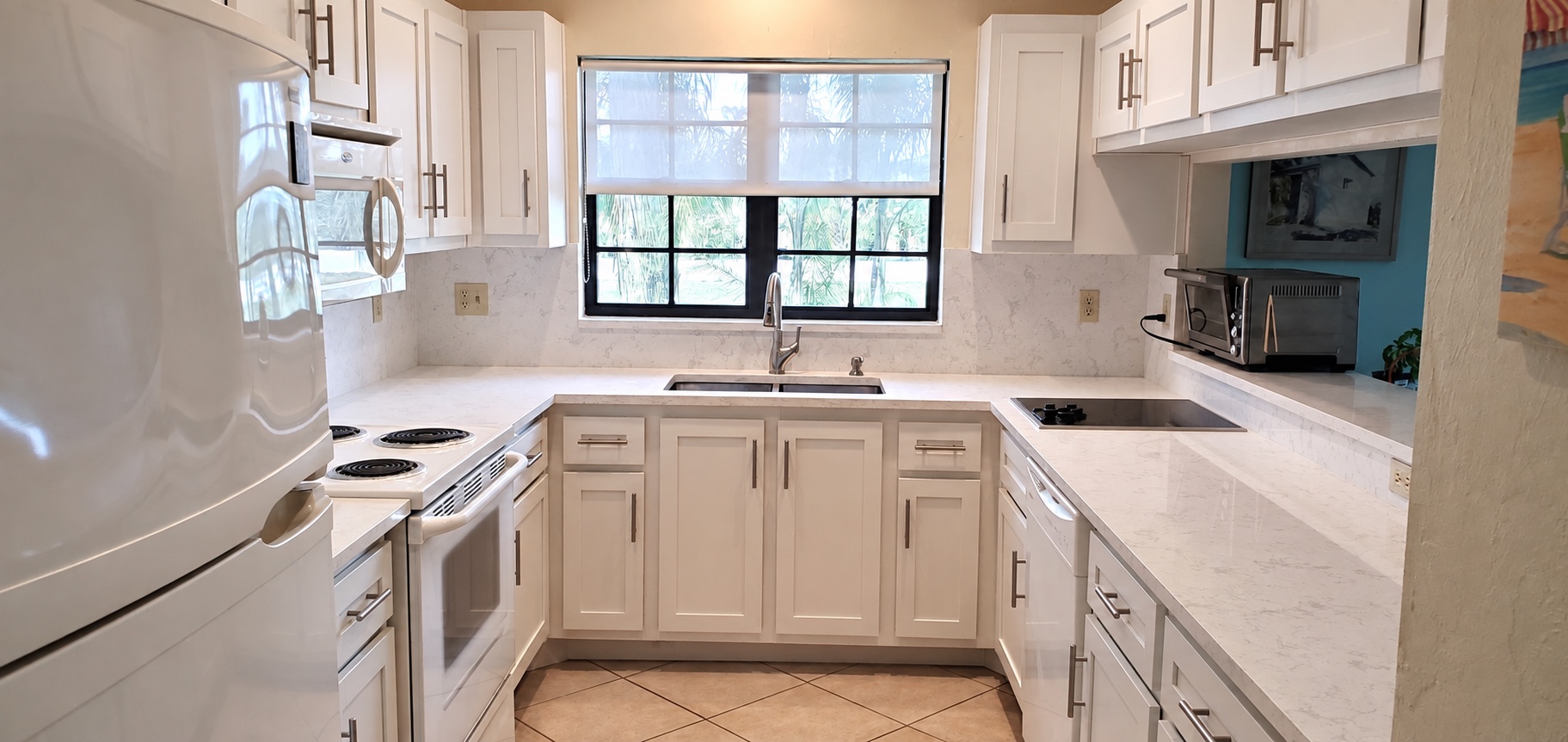 Refaced kitchen with white shaker doors, brushed nickel pulls and quartz counters